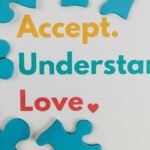 Colorful puzzle pieces with words 'Accept. Understand. Love.' symbolize autism awareness.