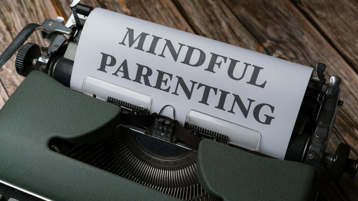 A typewriter with a paper reading 'Mindful Parenting' on a wooden surface.