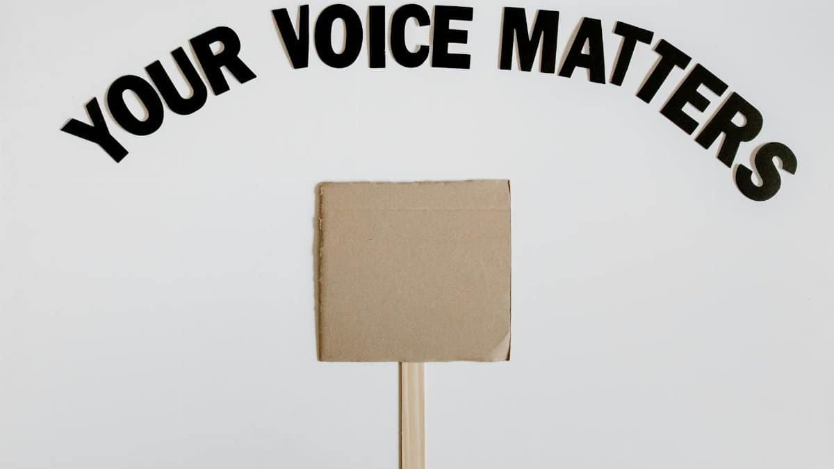 Image of a blank protest sign with 'Your Voice Matters' text overhead on a white background.