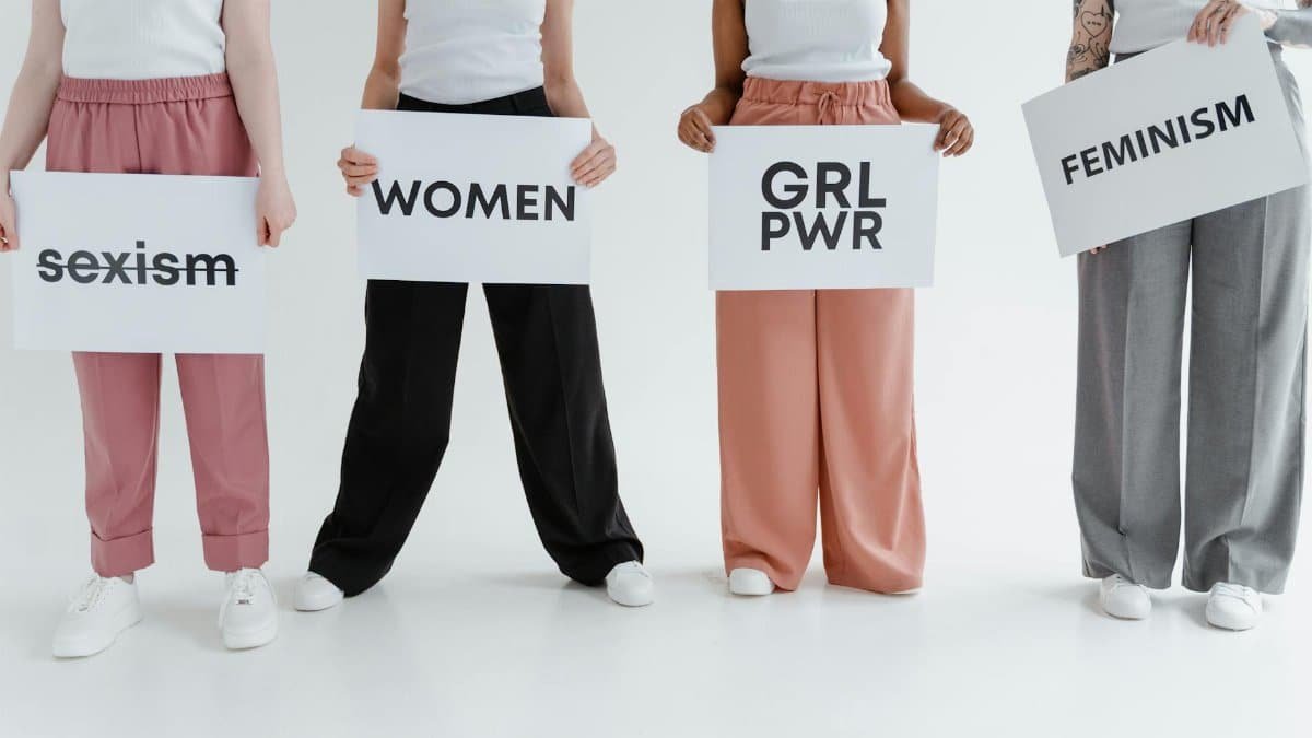 Four women holding signs with messages of empowerment and feminism.