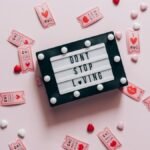 Letter board with 'Don't Stop Loving' surrounded by heart-shaped tickets and candies.