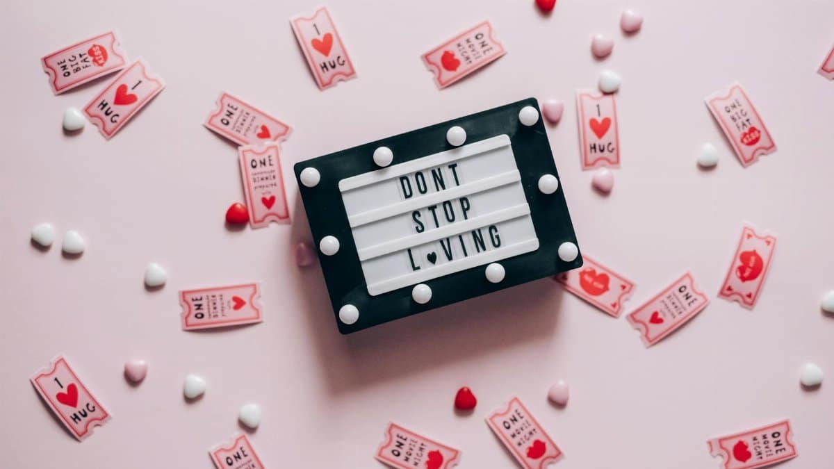Letter board with 'Don't Stop Loving' surrounded by heart-shaped tickets and candies.