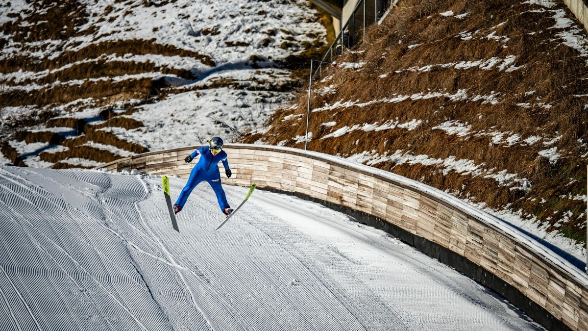 A thrilling ski jumper in vibrant blue suit captures the essence of winter sports at Planica.
