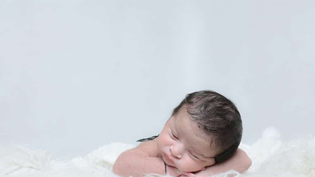 Charming portrait of a sleeping newborn baby on a cozy white blanket, exuding innocence and tranquility.