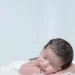 Charming portrait of a sleeping newborn baby on a cozy white blanket, exuding innocence and tranquility.