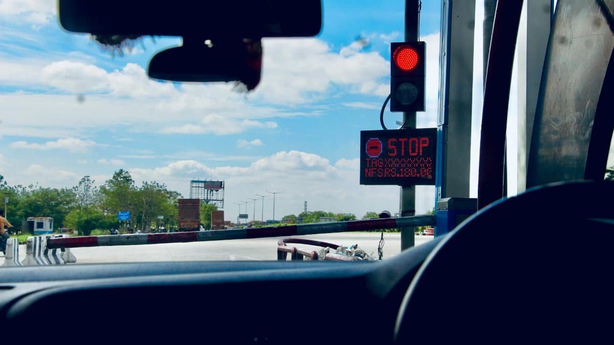 Car interior view at a toll booth in Suryapet, India with a stoplight.