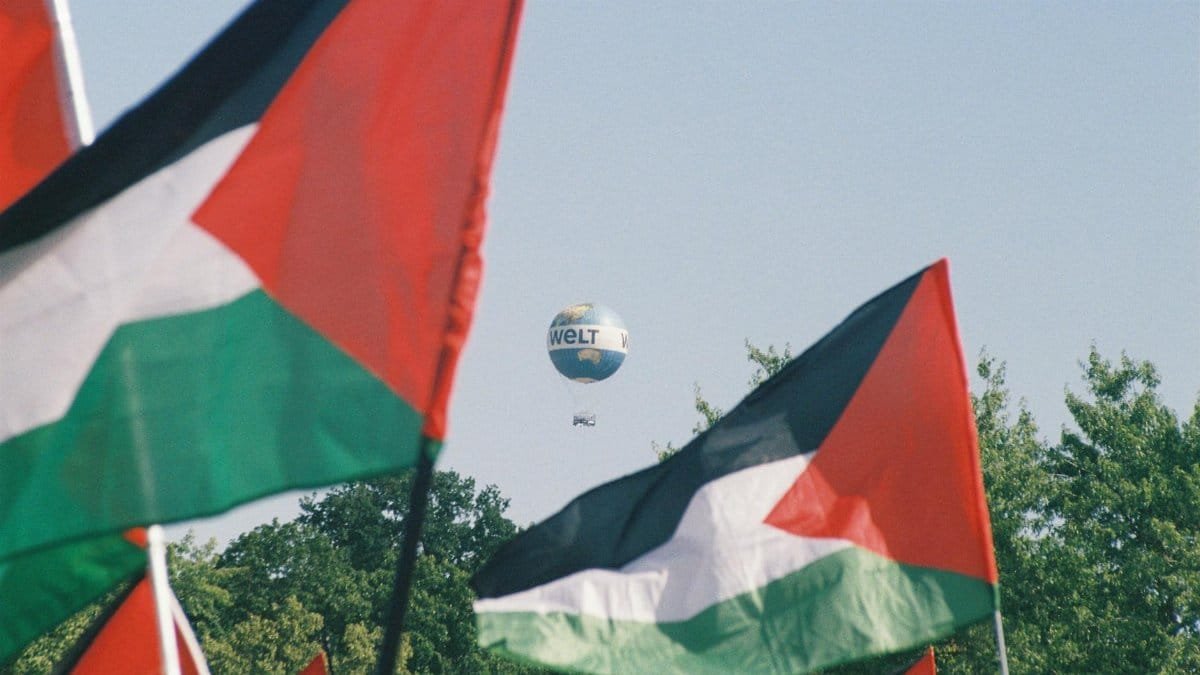 Palestinian flags with a Welt hot air balloon in Berlin, symbolizing awareness and protest.