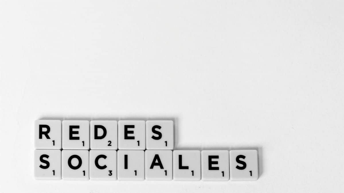 Scrabble tiles spelling 'Redes Sociales' illustrating a social media concept on a white background.