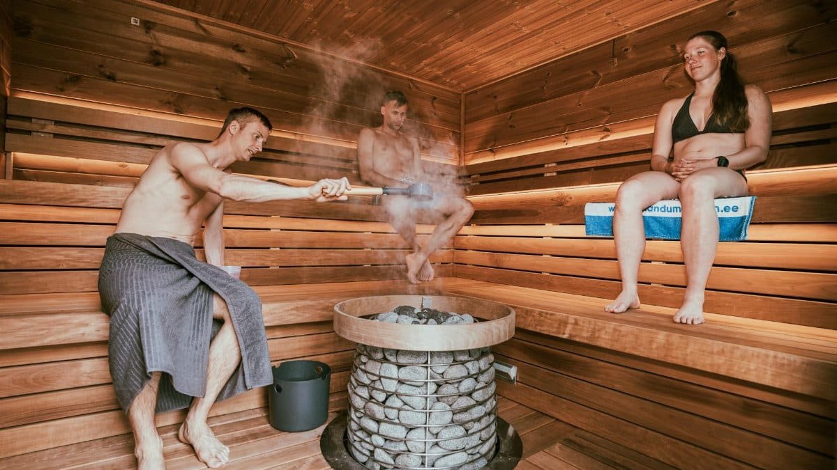 Three people enjoying a steamy sauna session, embracing wellness and relaxation.