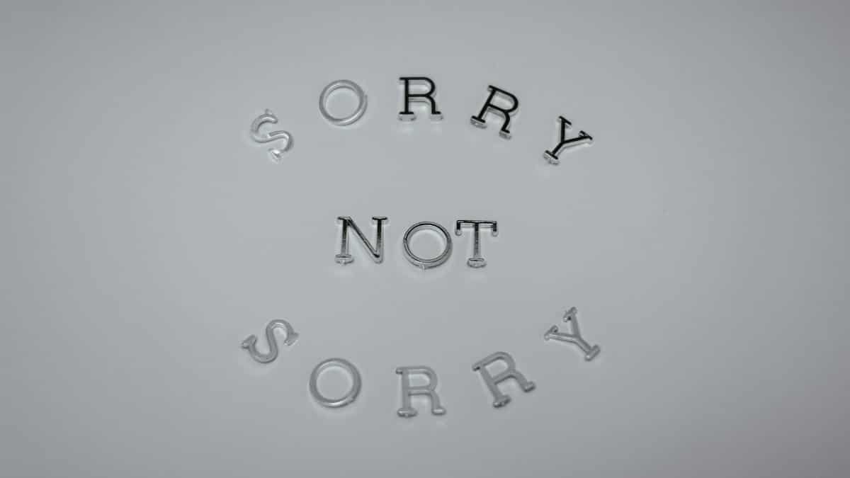 Minimalist design featuring the phrase 'Sorry Not Sorry' arranged in a circular pattern on a white background.