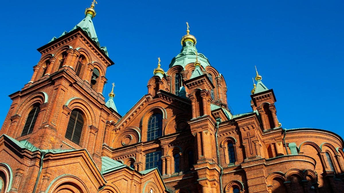 Stunning low-angle shot of Uspenski Cathedral in Helsinki, showcasing Russian Revival architecture against a blue sky.