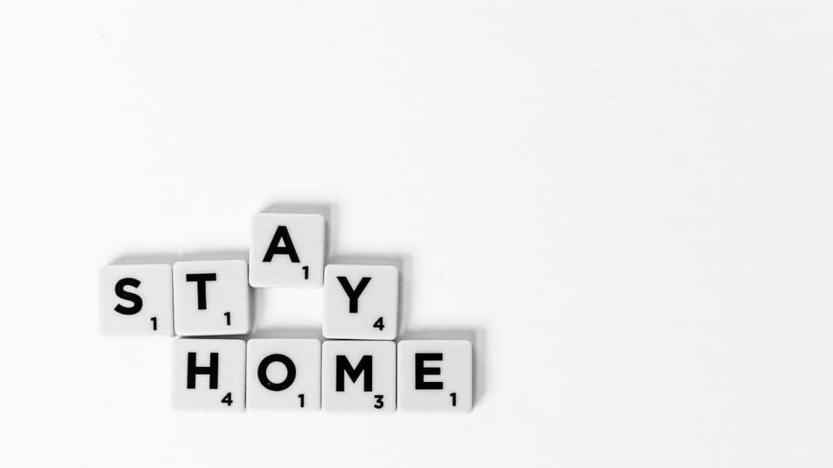 A conceptual image with the message "Stay Home" spelled out using Scrabble tiles on a white background.