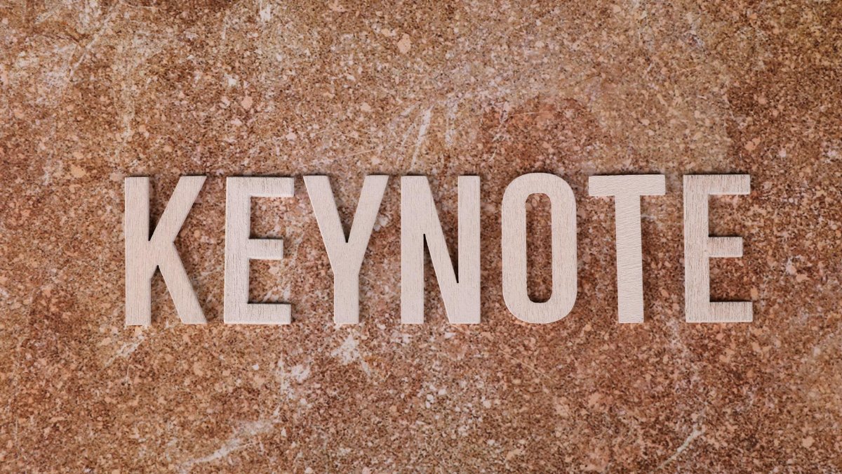 Wooden letters spelling 'KEYNOTE' on a textured stone surface, ideal for presentations.