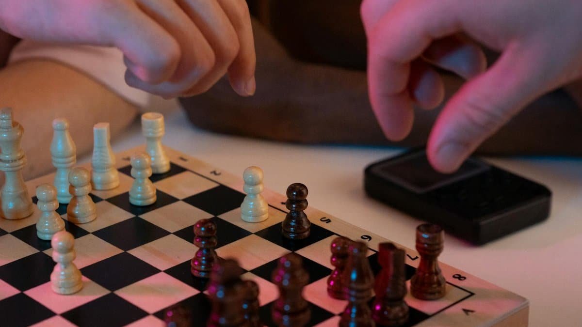 Close-up of hands playing a chess game, capturing strategic moves and intense focus.