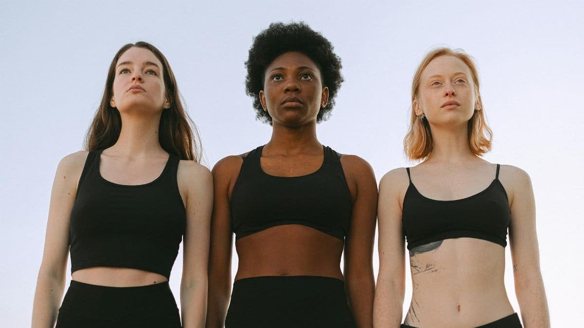 Three diverse women confidently standing together, symbolizing empowerment and unity.