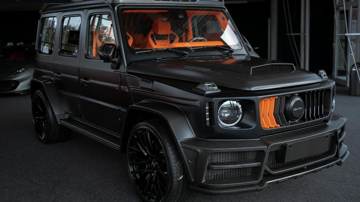 A high-end black SUV with custom orange accents showcased in a sophisticated garage.