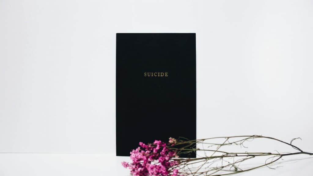 Minimalist art highlighting suicide awareness with flowers on a white background.