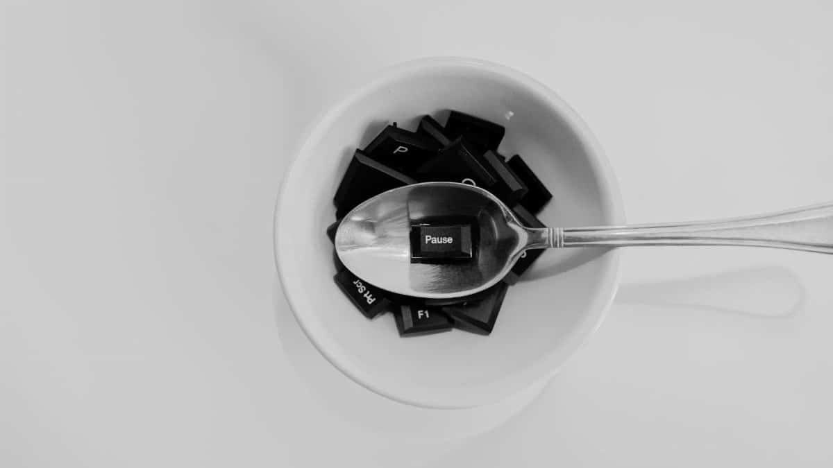 Unique black and white photo of keyboard keys in a bowl with a spoon featuring the 'Pause' key.