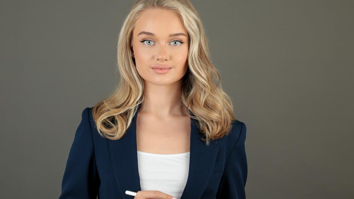 Confident businesswoman in blue suit holding tablet, depicting leadership and technology.