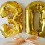 Golden 30 balloon with a wrapped gift box for a 30th celebration or birthday.