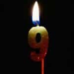 Burning number nine candle against a dark backdrop, perfect for birthdays or anniversaries.