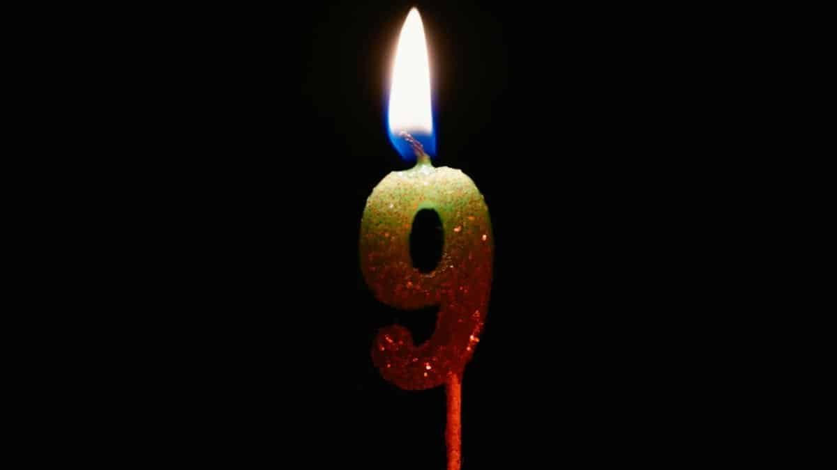 Burning number nine candle against a dark backdrop, perfect for birthdays or anniversaries.
