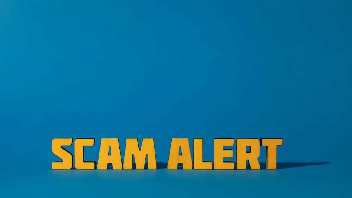Bold yellow 'Scam Alert' text on a vivid blue surface, emphasizing warning and caution.