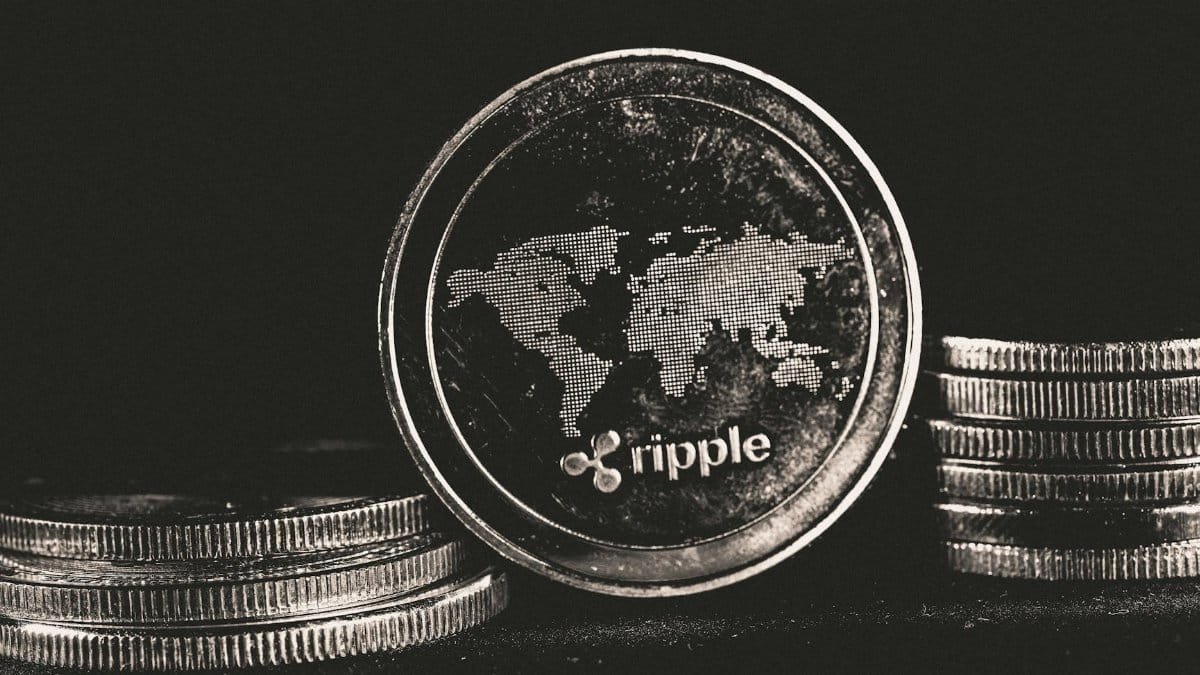 A detailed shot of a Ripple coin with a world map design on a black background.