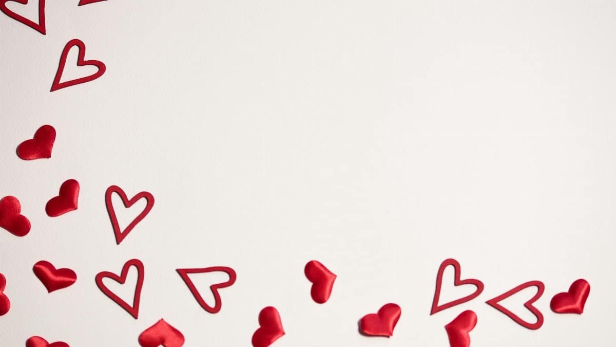 Red hearts scattered on a white background, ideal for Valentine's Day or romantic themes.