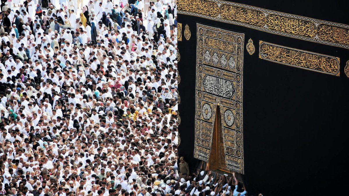 Mass of pilgrims in traditional attire at Kaaba during the Hajj pilgrimage.