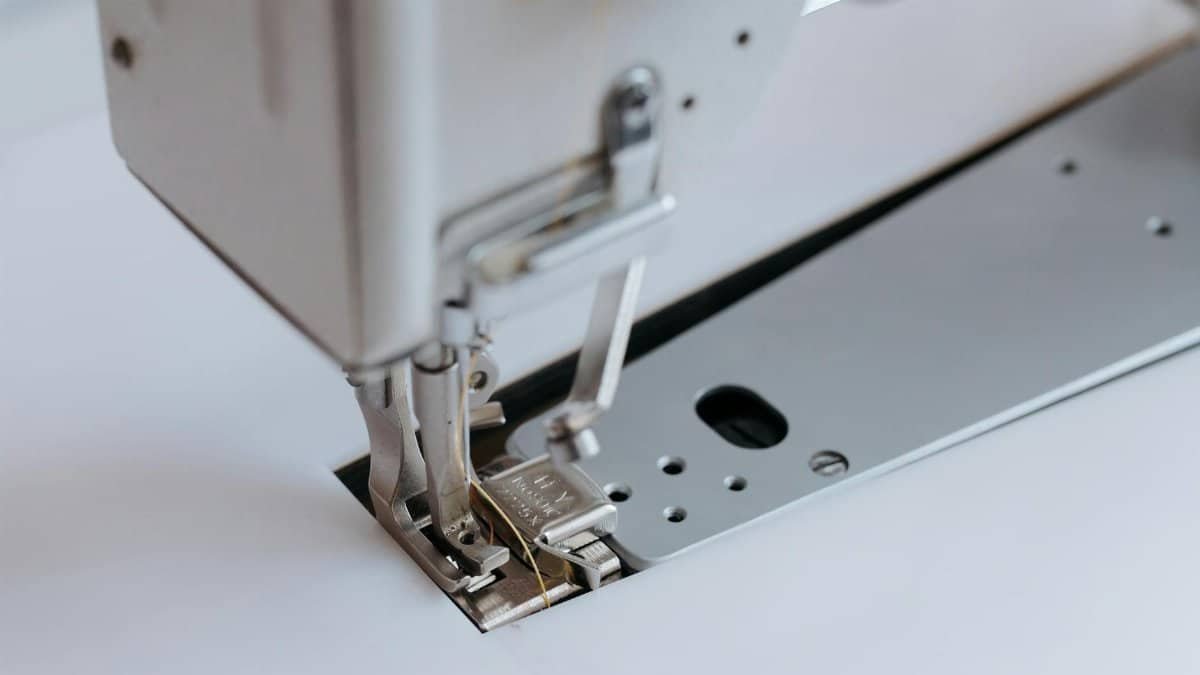 Detailed view of a sewing machine with focus on the needle and presser foot, showcasing precision tools.