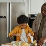 Father and son prepare dinner in a stylish kitchen, enjoying quality time together.