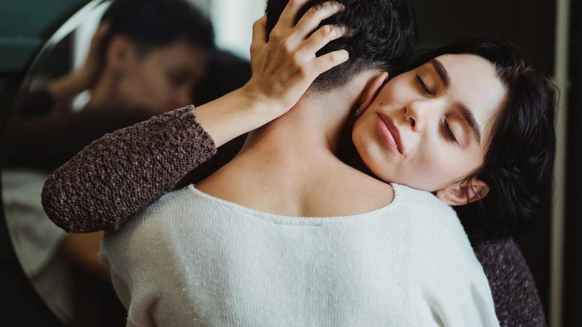 Tender embrace between two women sharing a moment of affection and connection indoors.