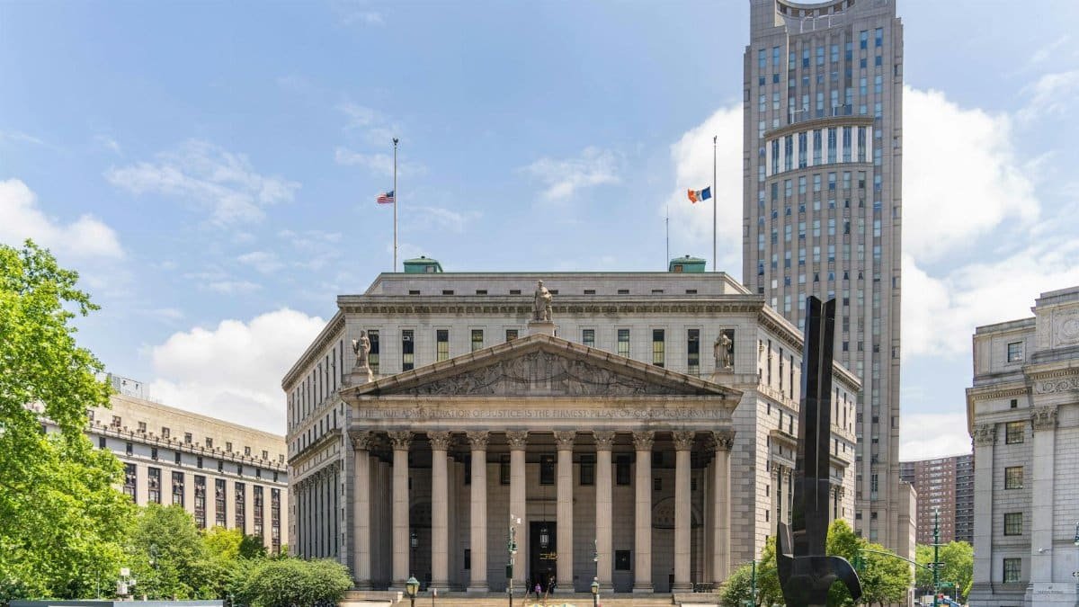 View of the historic New York County Courthouse with clear skies and cityscape.