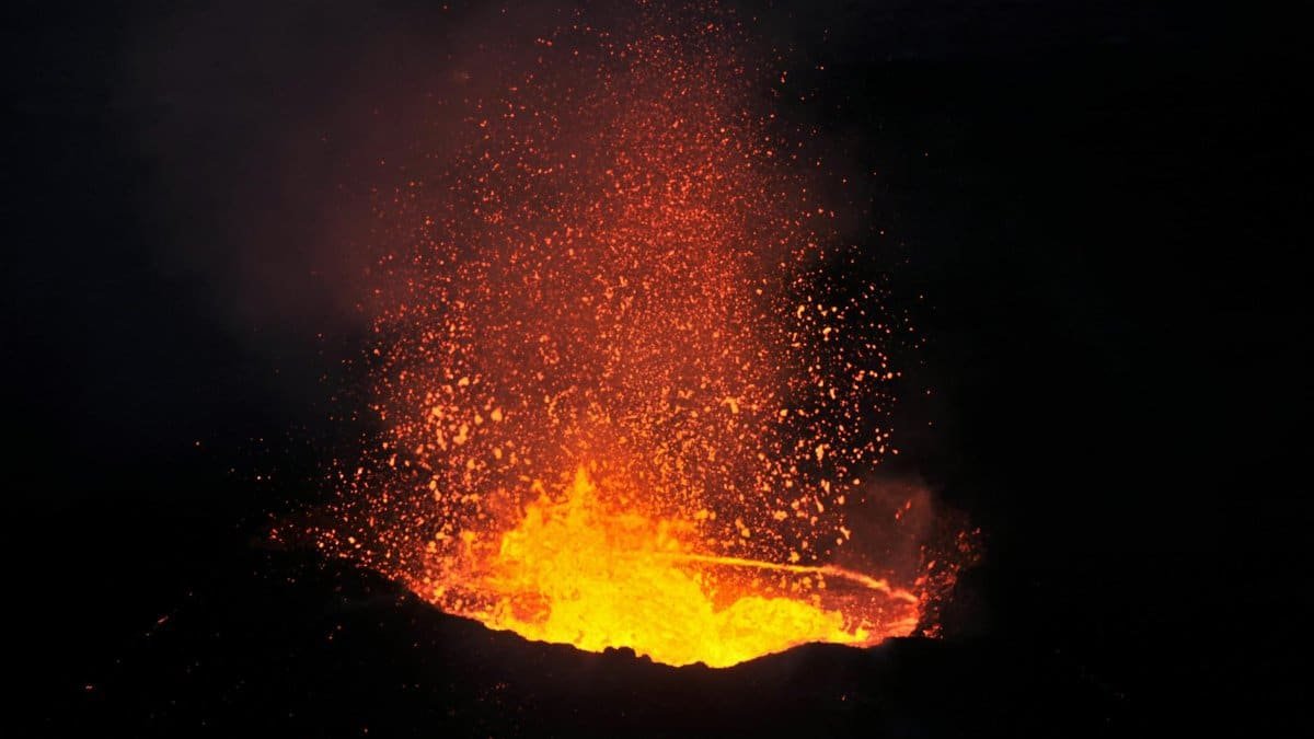 Stunning image of a volcano eruption with fiery lava against the night sky.