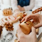 Close-up of hands engaging with wooden brain teasers on a table indoors.