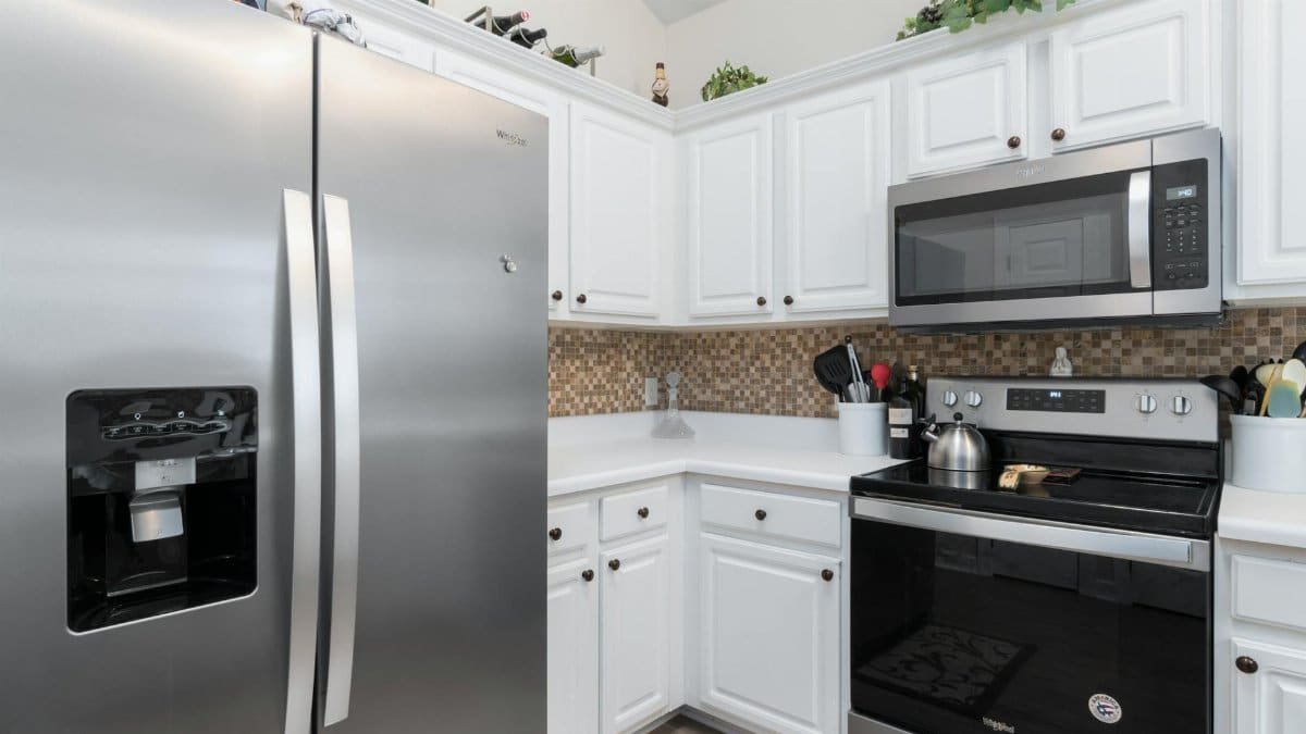 Contemporary kitchen interior featuring modern stainless steel fridge and microwave.