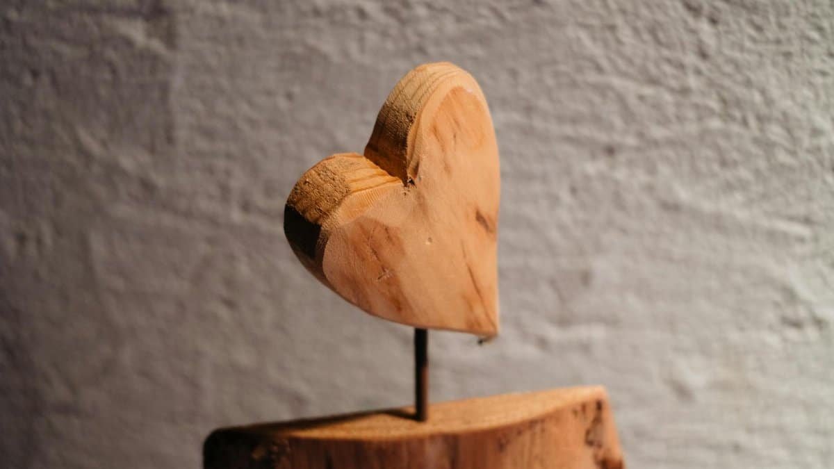A close-up of a rustic wooden heart sculpture, ideal for romantic or artistic decor.