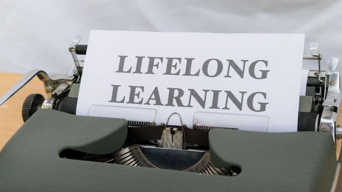 Close-up of a vintage typewriter displaying 'Lifelong Learning' on paper.