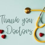 A stethoscope with hearts and 'Thank You Doctors' inscription on a blue background.