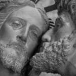 Close-up of a sculpture depicting the kiss of betrayal by Judas to Jesus in grayscale.