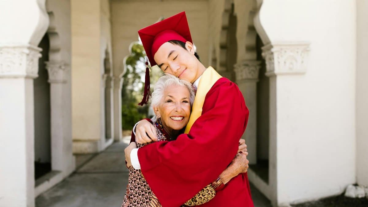 A graduate embraces his grandmother, capturing a heartfelt moment of achievement and love.