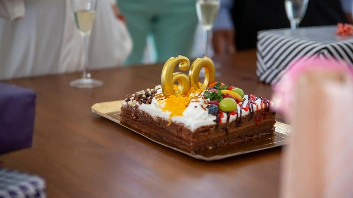 A delicious chocolate cake with 60 candles, perfect for a milestone birthday celebration.