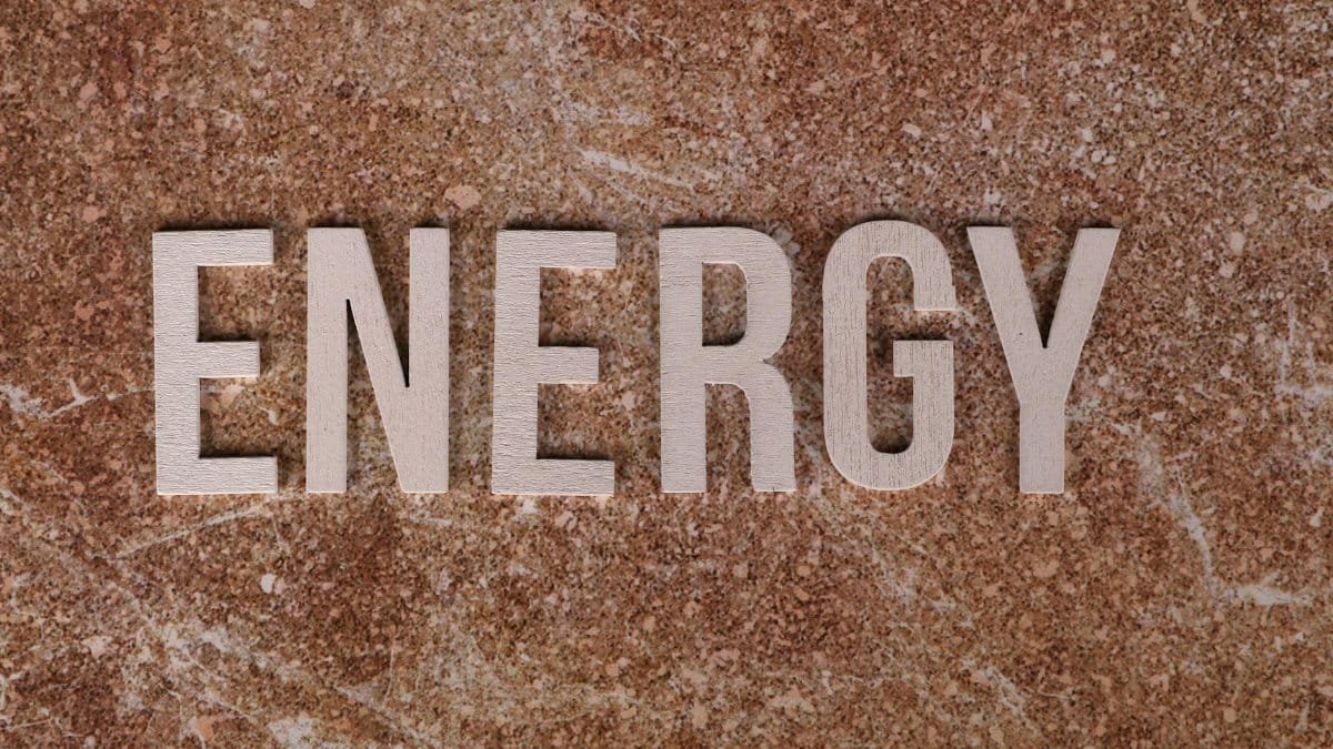 Word 'Energy' on natural stone texture, symbolizing raw power.