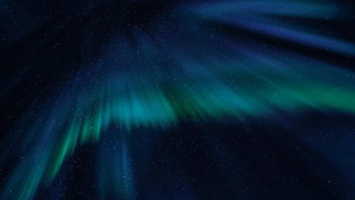 Breathtaking view of the aurora borealis illuminating the starry night sky with vibrant green and blue hues.