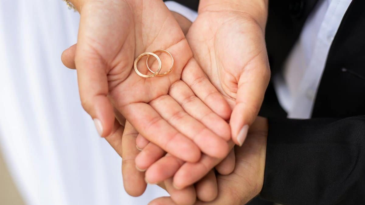 A close-up shot of a couple holding wedding rings in their hands, symbolizing love and unity.