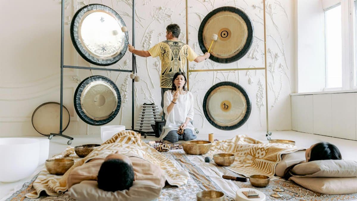 Experience tranquility in a calming sound bath with singing bowls and gongs promoting relaxation and well-being.