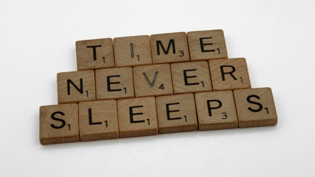 Wooden Scrabble tiles arranged to spell 'Time Never Sleeps' on a white background.