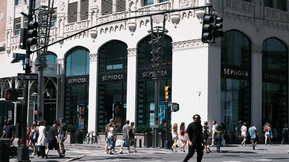 A lively city scene showcasing a Sephora storefront with pedestrians crossing the street.