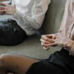 A couple sitting on a sofa during a therapy session, portraying tension and worry.